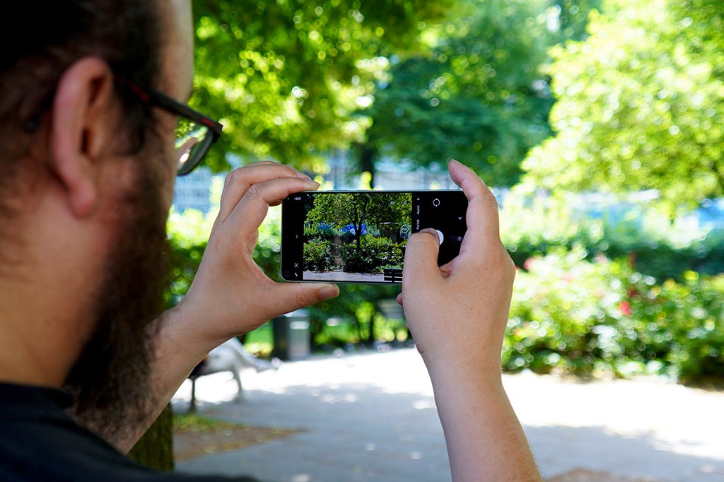 Ein Mann fotografiert mit einem Smartphone.