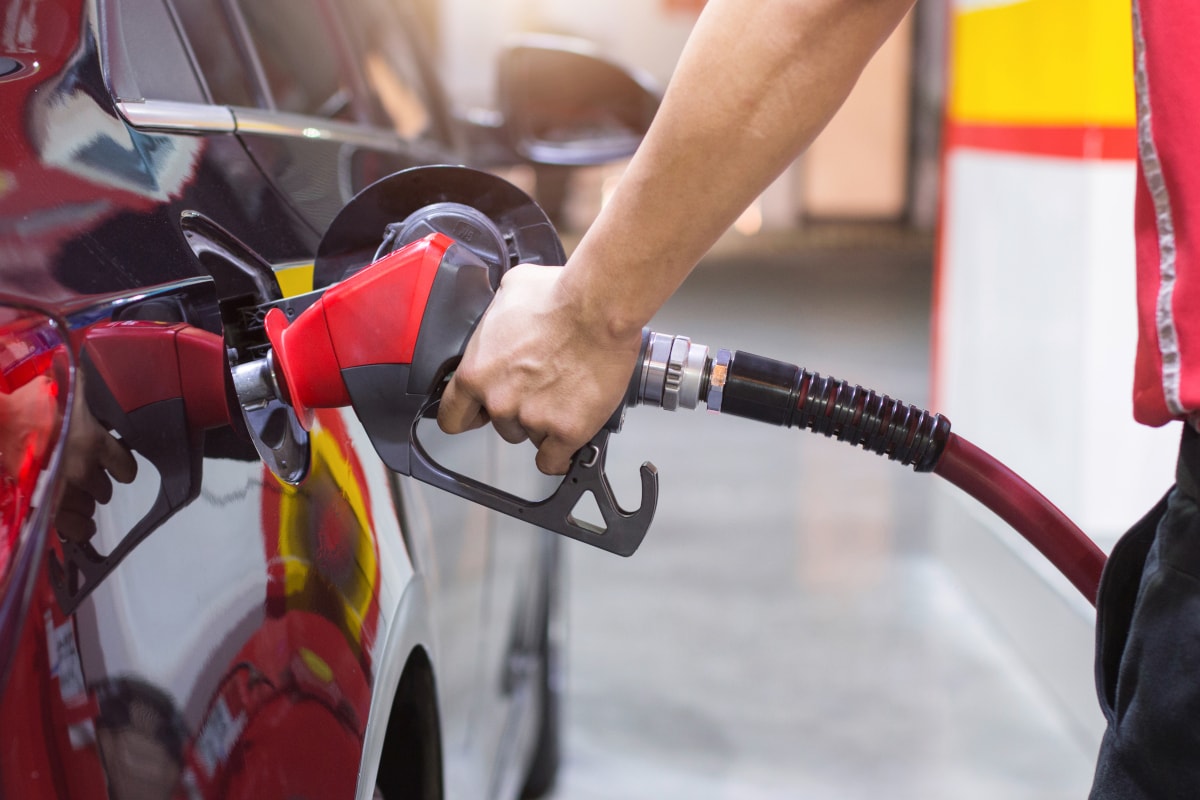 Hand hält Zapfdüse zum Tanken in Auto-Tank