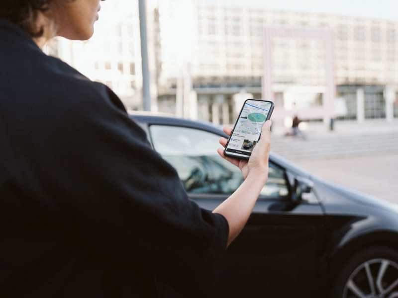 Eine Frau blickt auf ein Smartphone in der Hand.