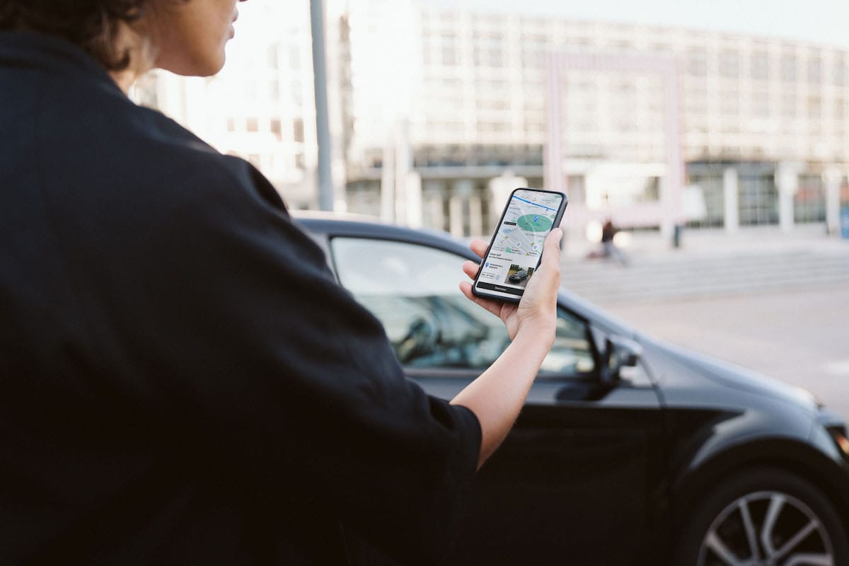 Eine Frau blickt auf ein Smartphone in der Hand.