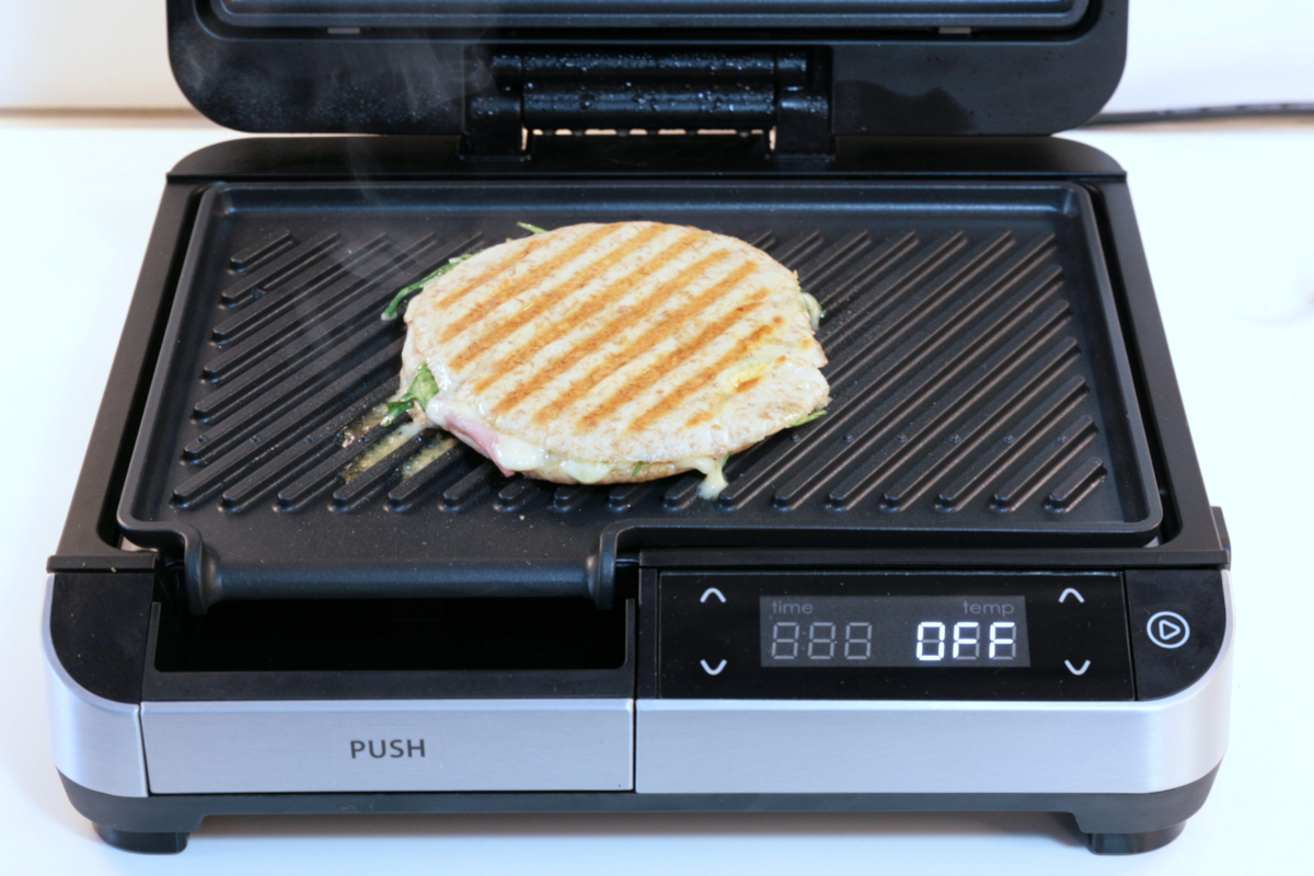 Geöffneter Kontaktgrill mit gebratenem Panini