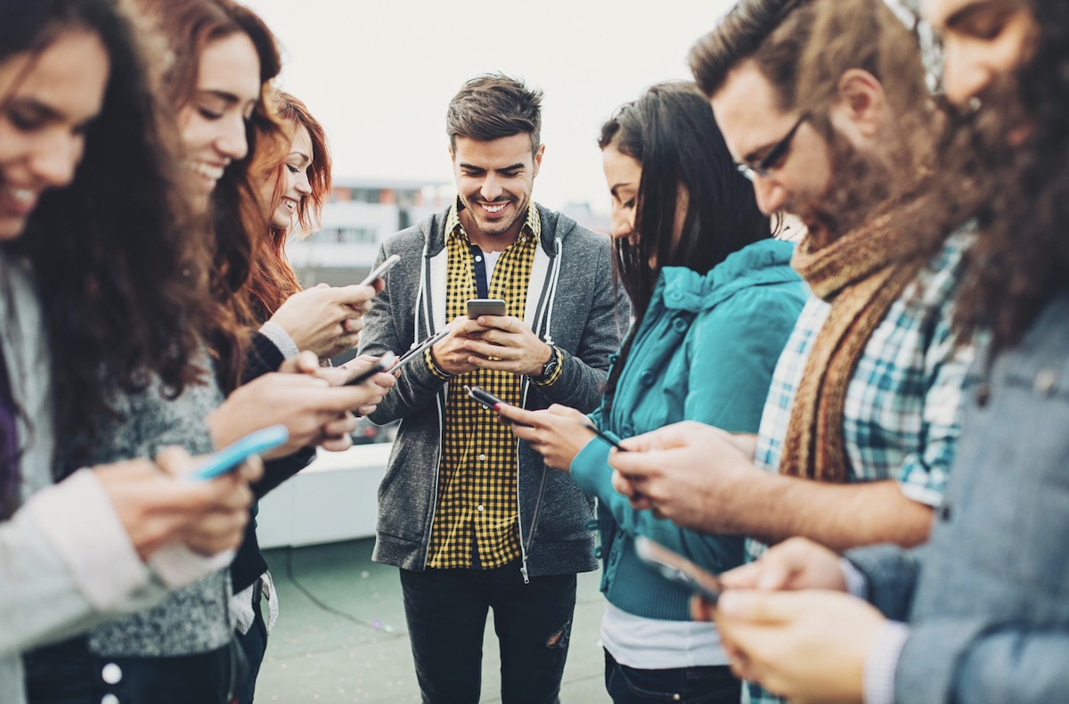 Menschen mit einem Smartphone stehen im Kreis