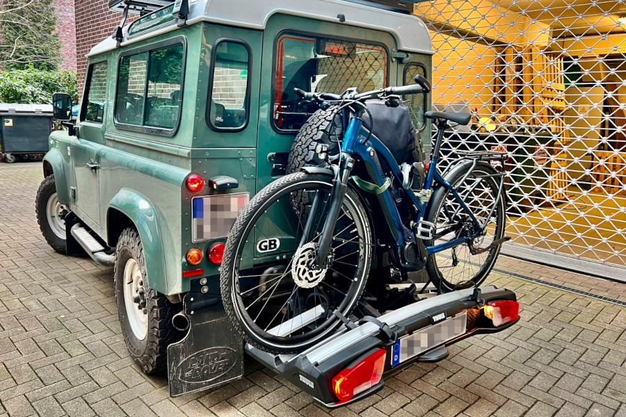 Grüner Geländewagen von hinten mit Trekking-E-Bike drauf