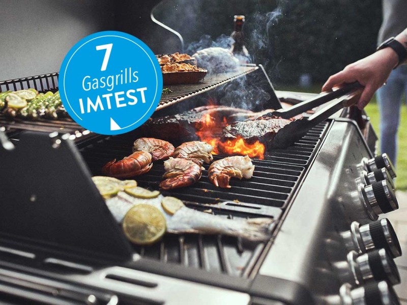 Burnhard Gasgrill in Betribe mit verschiedenem Fleisch, blauer Sticker mit Gasgrills imtest