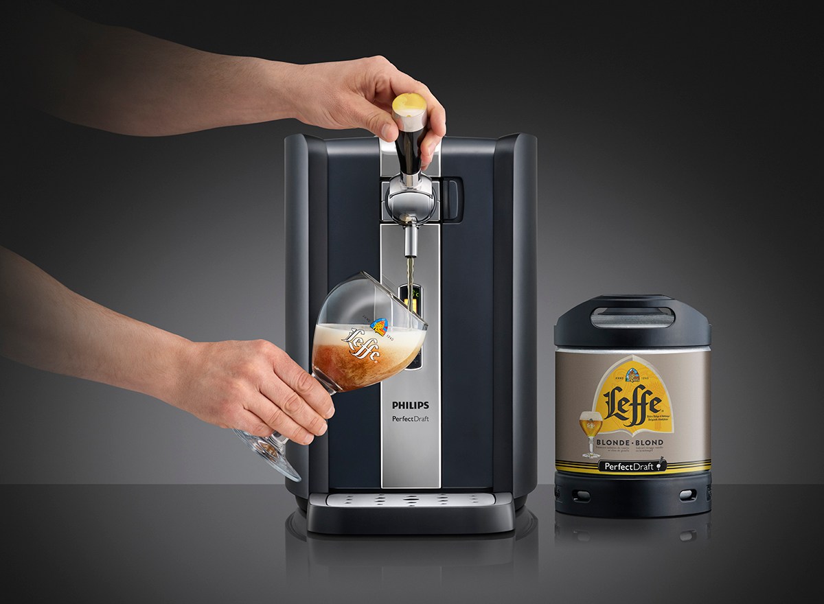 Person zapft frisches Bier aus der Bierzapfanlage PerfectDraft