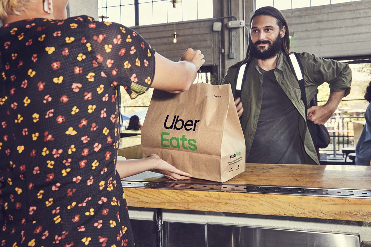 Ein Mann nimmt eine Essensbestellung von Uber Eats entgegen.