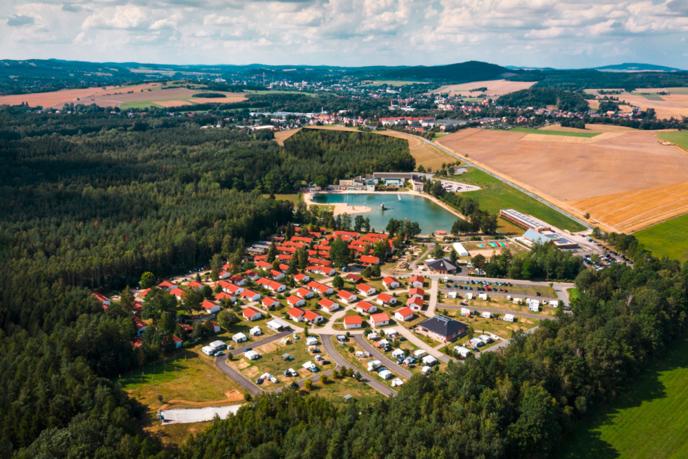 Campingplatz von oben zwischen Wald und Feldern