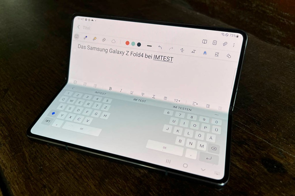 Das Samsung Galaxy Z Fold4 aufgeklappt mit Notizapp, unter Bildhälfte Tastatur