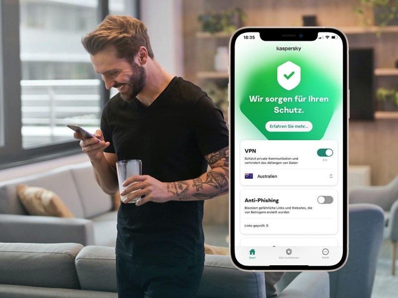Kaspersky Screenshot auf einem Handy vor einem Mann, der ein Smartphone in der Hand hält