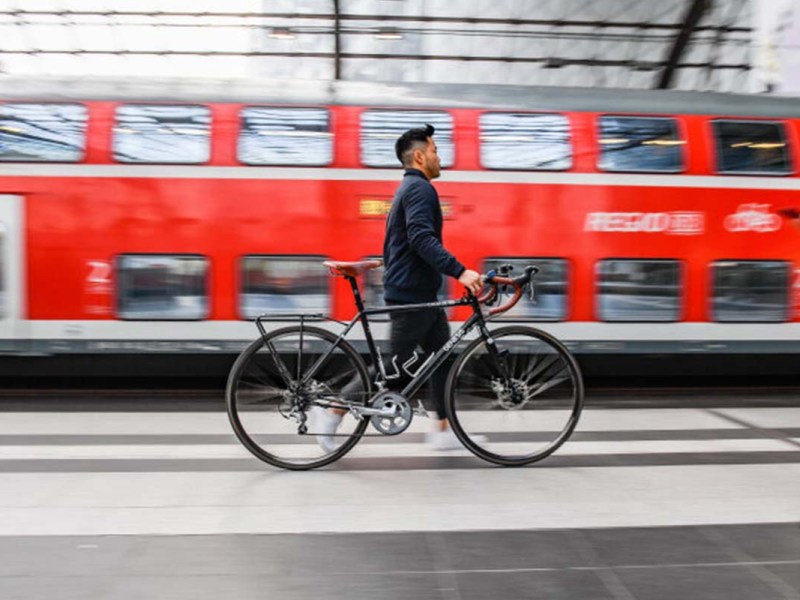 Ein Reisender schiebt ein Fahrrad über den Bahnsteig im Berliner Hbf