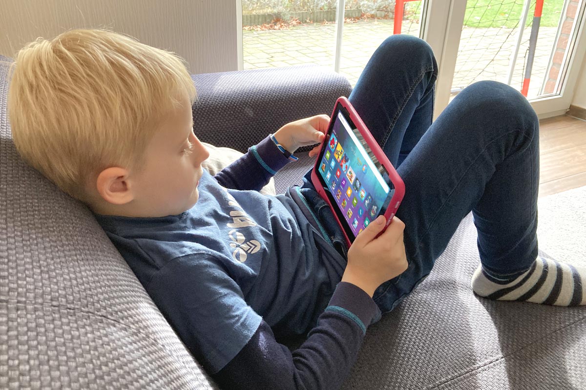 Kind sitzt auf Sofa mit Amazon Fire HD 8 Kids Pro in den HÃ¤nden