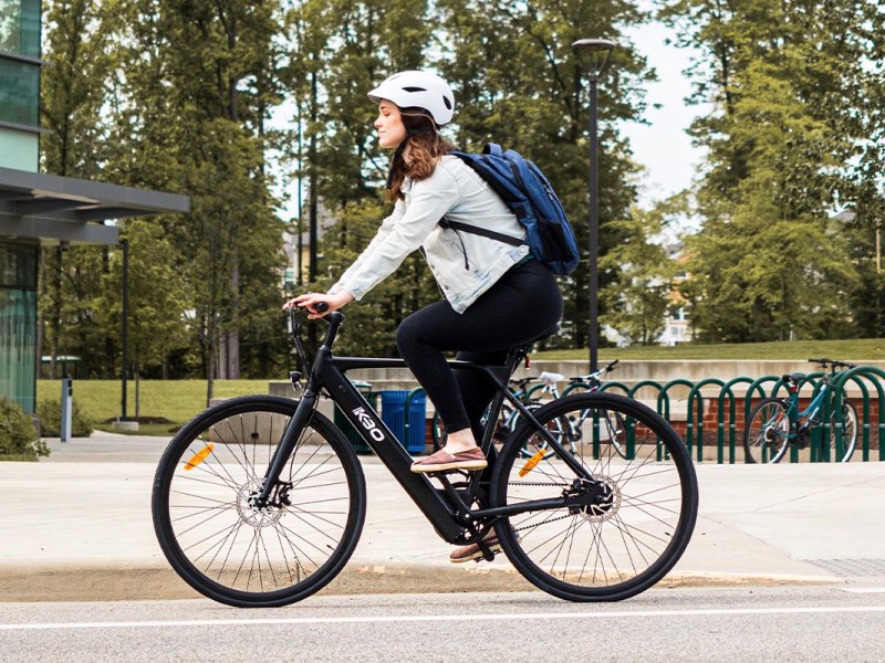 Eine Frau auf einem E-Bike auf der Straße fahrend