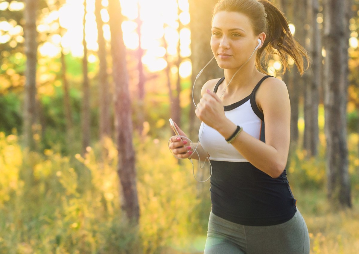 Frau joggt durch sonnige Landschaft