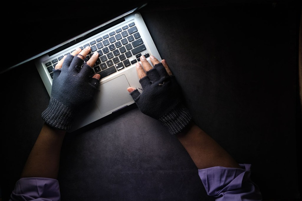 Hände einer Person tippen auf einer Laptop-Tastatur.