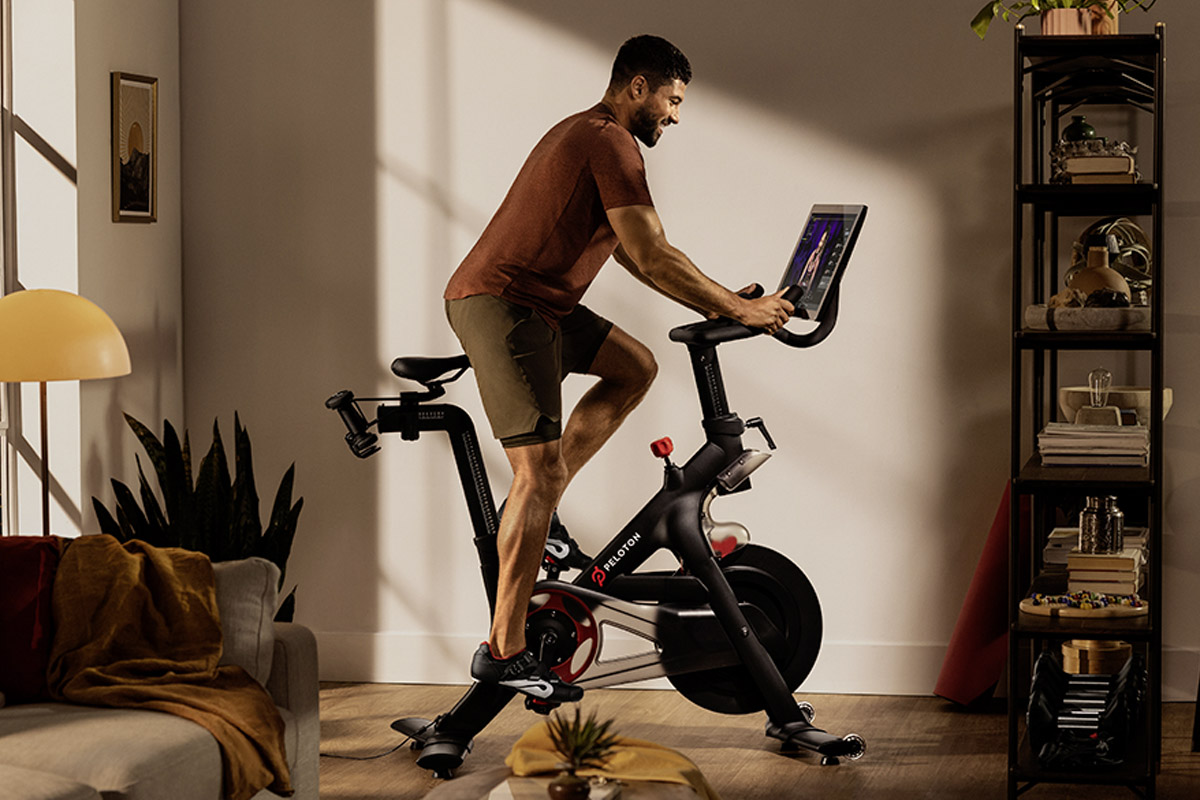 Ein Mann fährt ein Peloton Bike in seiner Wohnung.