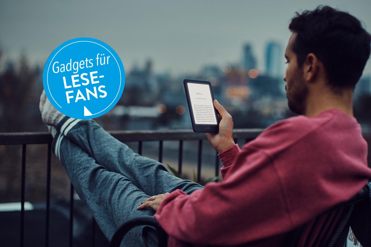 Ein Mann sitzt in der Dämmerung auf dem Balkon und liest in seinem EBook-Reader