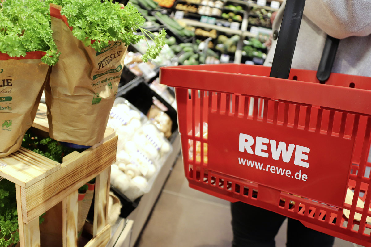 Eine Frau kauft bei Rewe Lebensmittel ein.