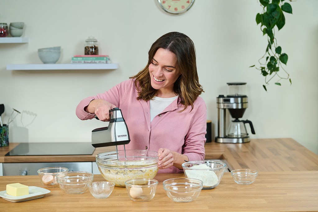 Eine Frau bearbeitet mit dem neuen Akku-Handmixer von Severin Kuchenteig.