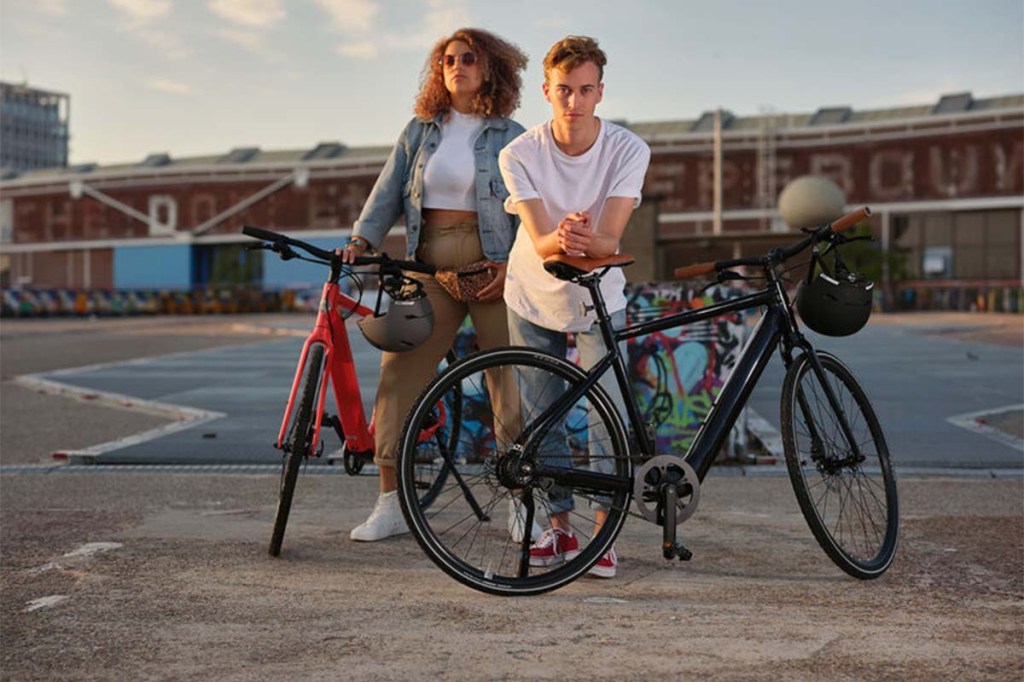 Zwei Menschen mit E-Bike MOmentum Voya E+ in der Stadt
