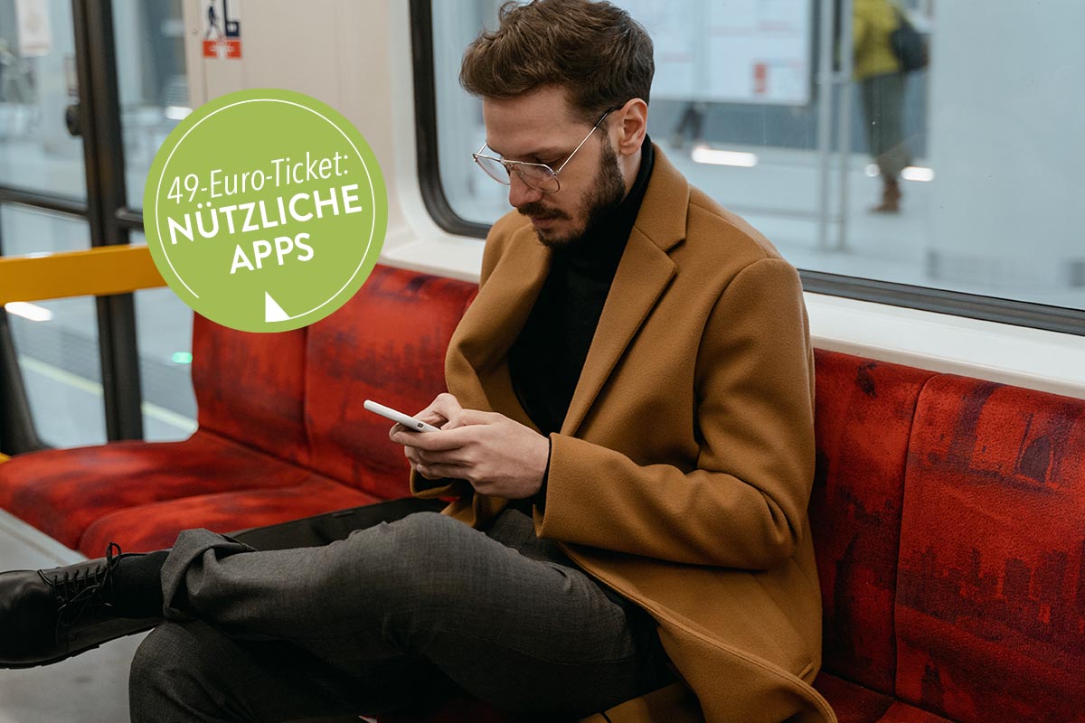 Mann in einer Bahn mit einem Smartphone in der Hand