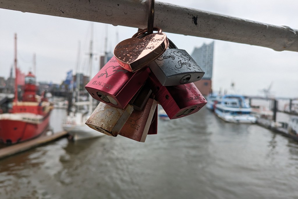 Schlösser hängen an einer Brücke.