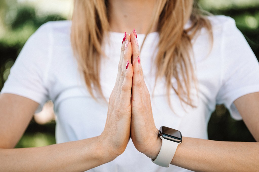 Eine Frau führt den Yoga-Gruß aus.