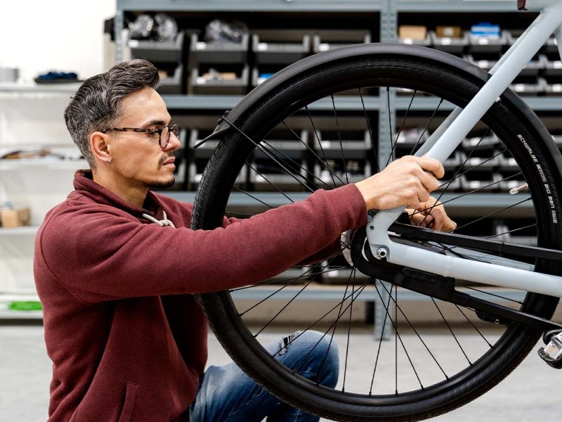 Fahrrad im Anschnitt, wird von einem Mechaniker repariert