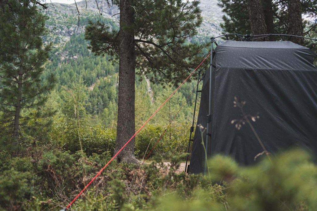 Duschzelt Qeedo in einem Wald stehend