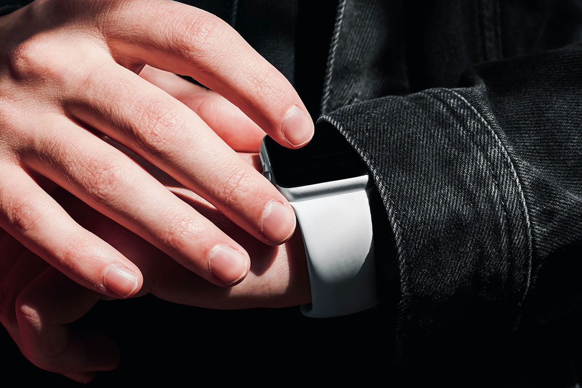 Eine Hand bedient eine Smartwatch am Handgelenk.