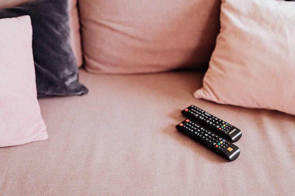 Zwei Fernbedienungen auf einem Sofa.