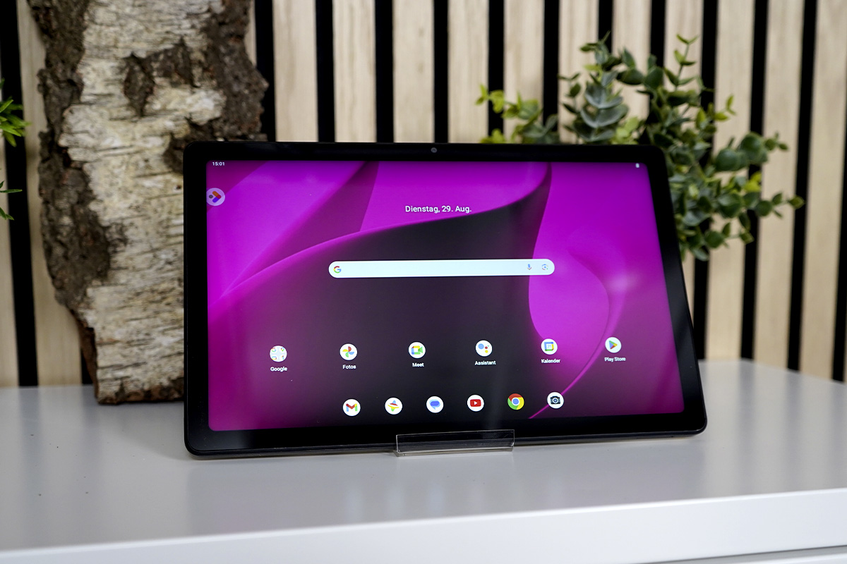 Das eingeschaltete Telekom T Tablet steht auf einbem Sideboard.