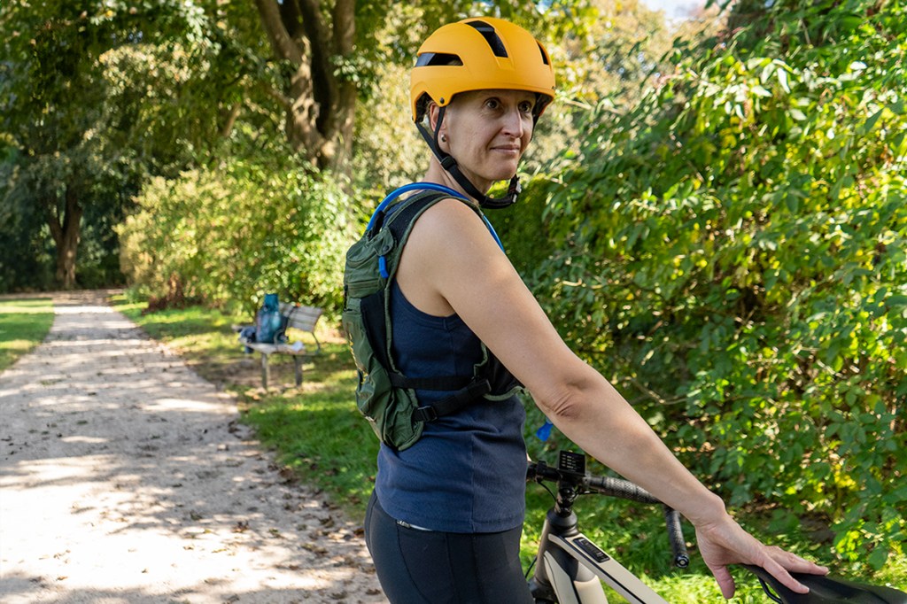 Frau mit Trinkweste am Fahrrad stehend