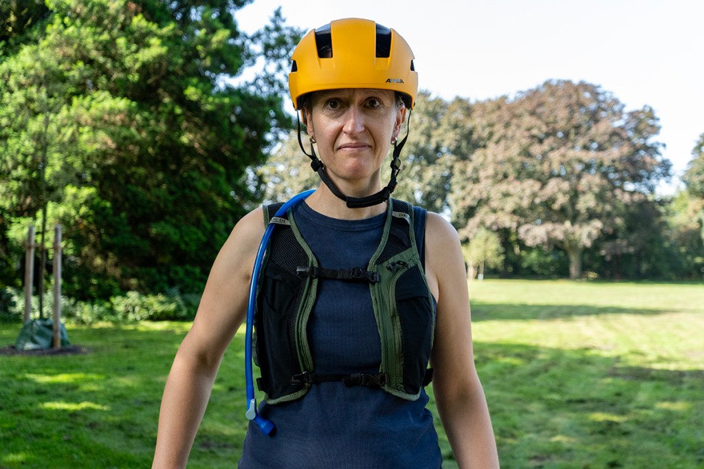 Frau von vorne, hat Trinkweste und Helm an