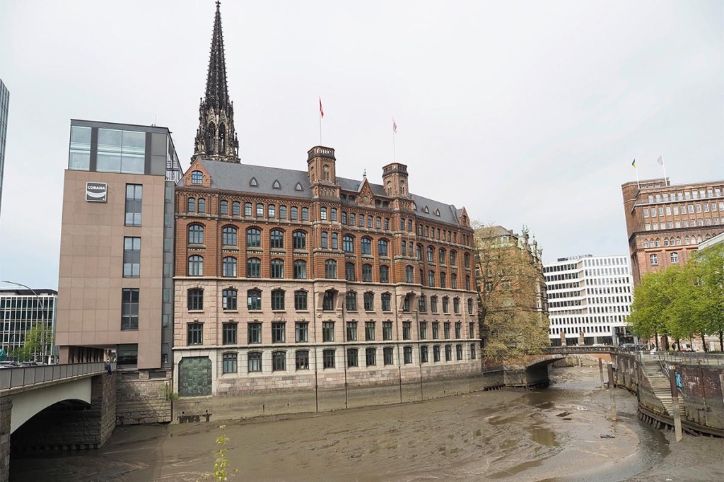 Gebäude an einem Fluss unter bewölktem Himmel.