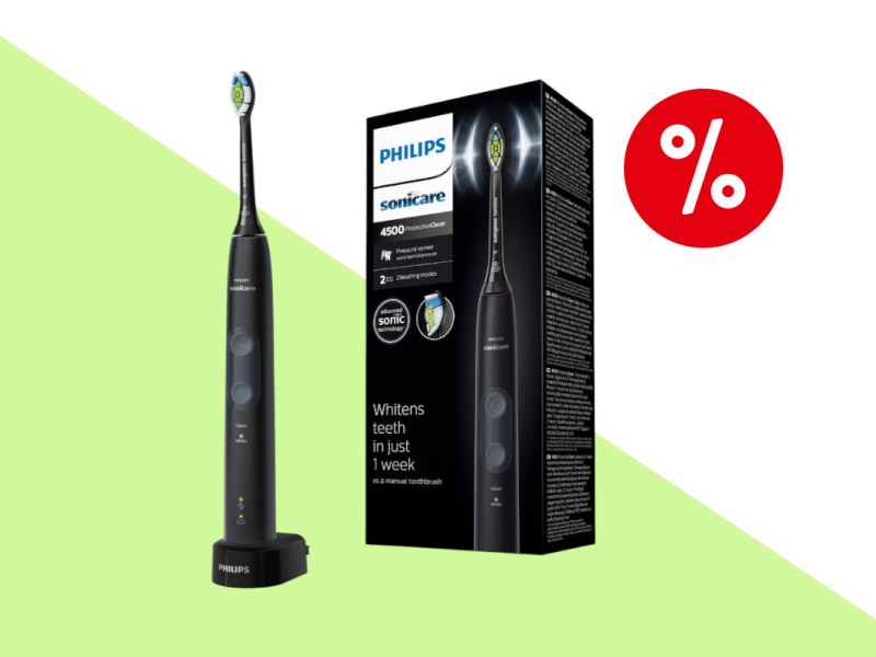 Schwarze Philips Sonicare ProtectiveClean 4500 links aufgestellt schräg von vorne, rechts etwas nach hinten versetzt der Karton schräg von vorne auf hellrün weißem Hintergrund mit rotem Prozentbutton oben rechts