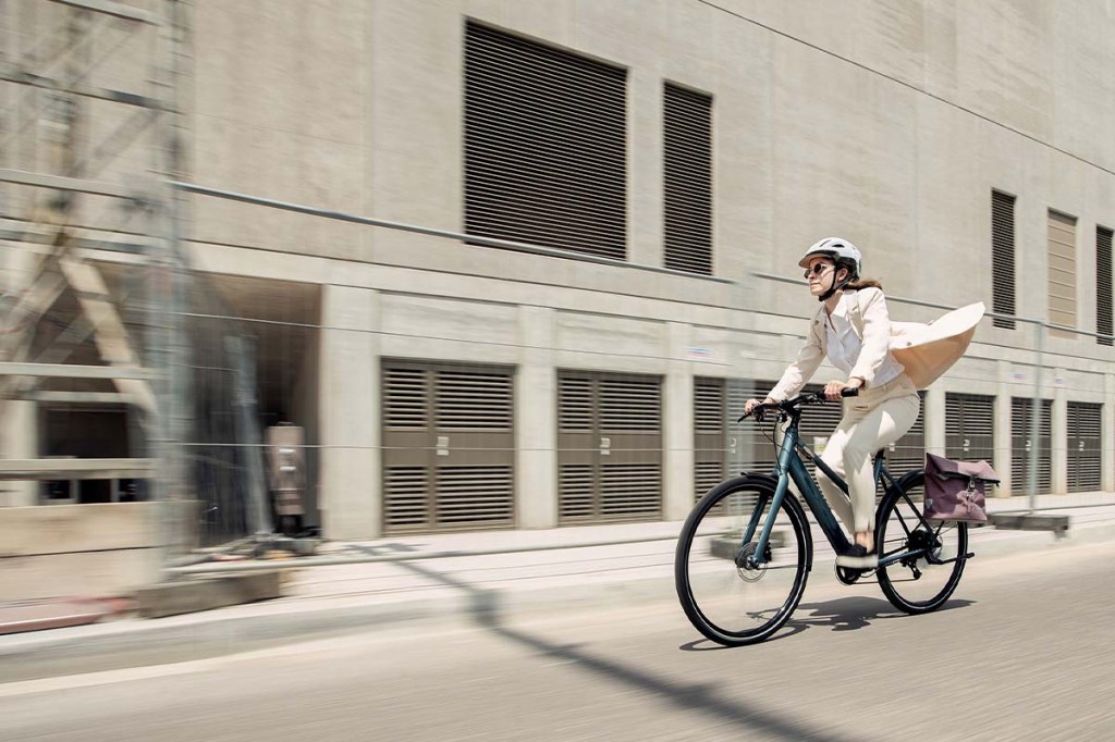 Frau fährt mit Fahrrad durch eine Stadt