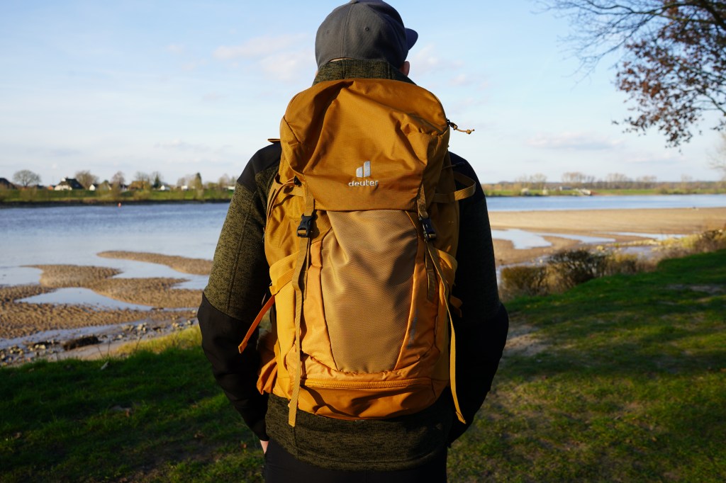 Mann von hinten, hat einen Rucksack auf dem Rücken 