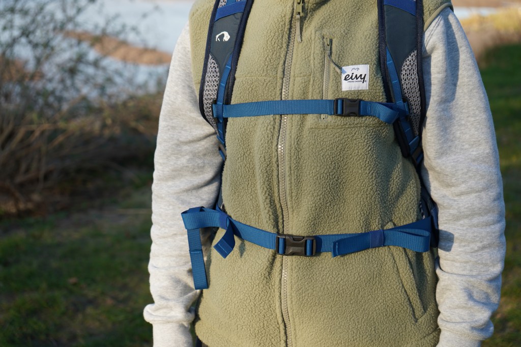 PErson im Anschnitt von vorne, die einen RUcksack trägt