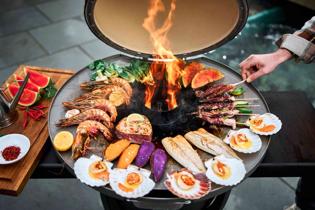Muscheln, Garnelen, Fisch und Gemüse auf der Feuerplatte des MONOLITH
