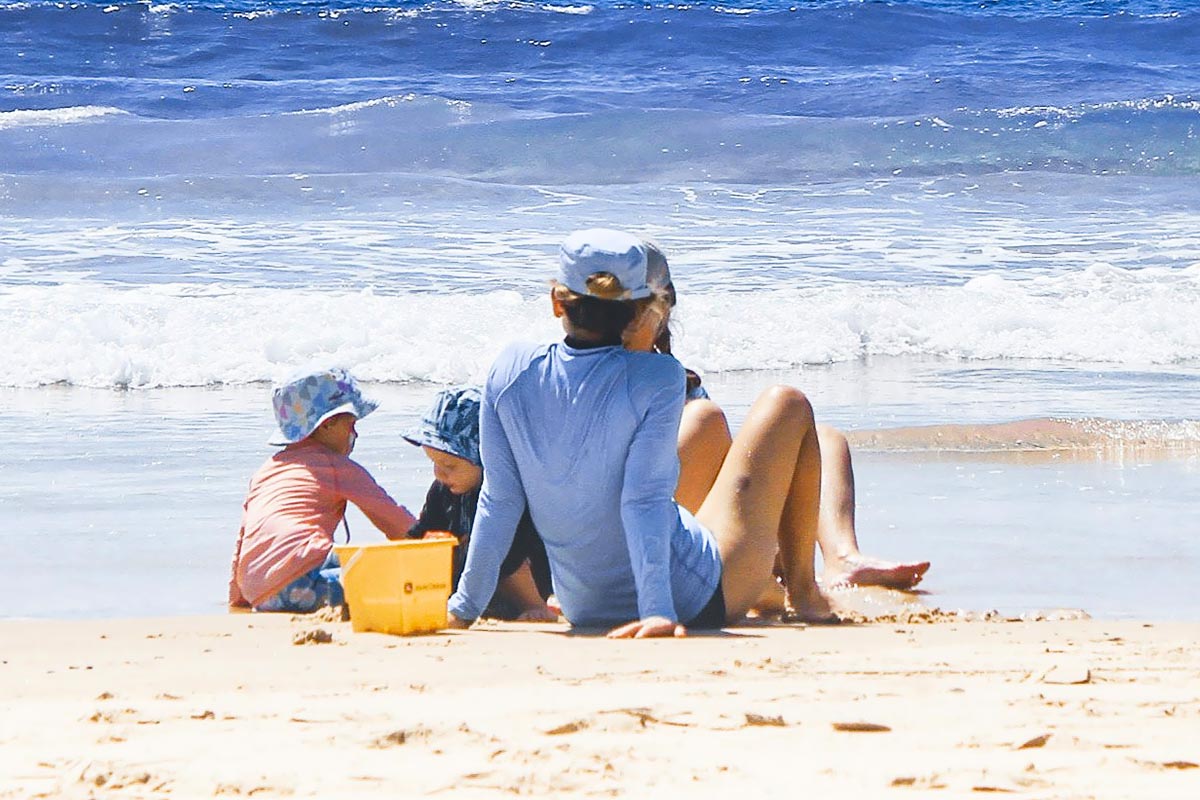 Familie mit Kindern an einem Strand.