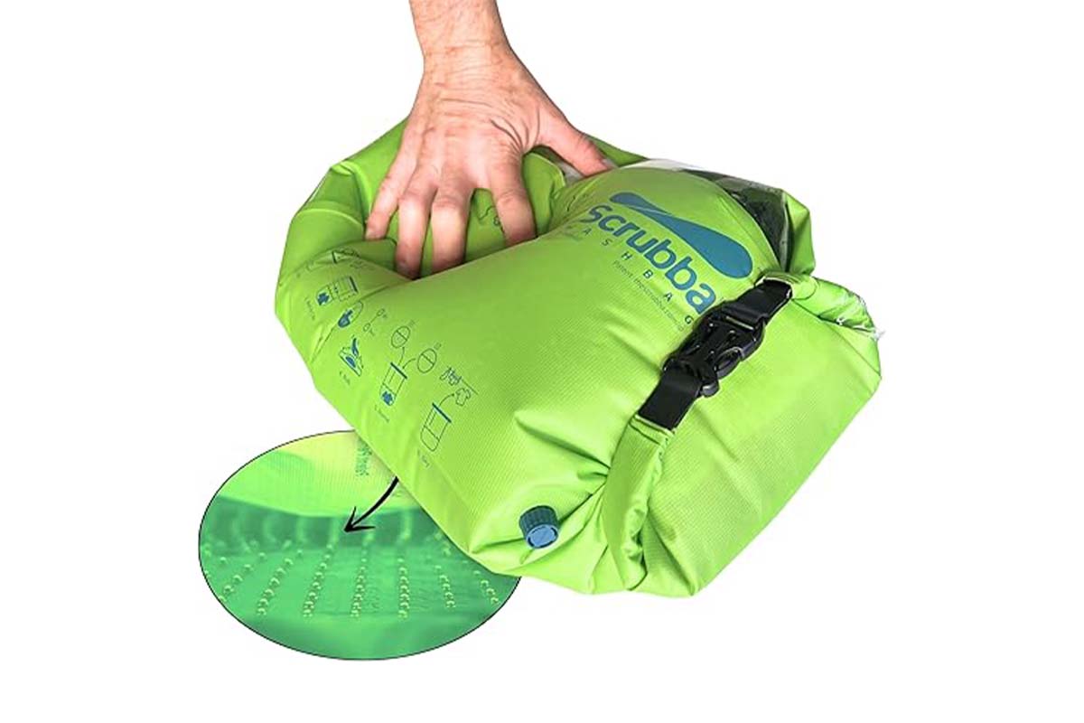grüner Waschsack, der von einer Hand gedrückt wird, dazu ein kleines Bild, das die innenliegenden Noppen zeigt, weißer Hintergrund