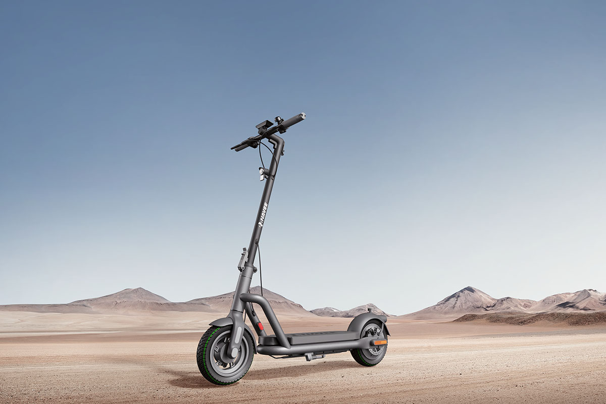 E-Scooter Navee N65i steht im Profil vor einer hügeligen Wüstenlandschaft.