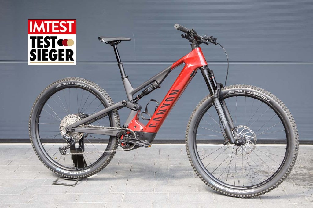 Totale rotes E-Mountainbike mit Testsieger-Grafik