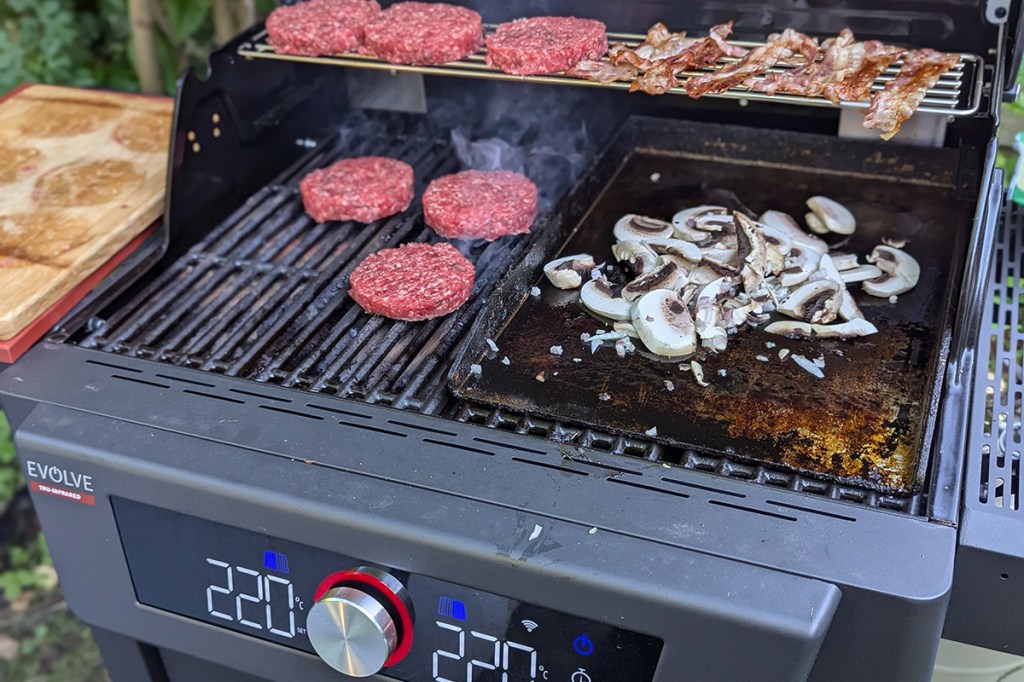 Der Grillrostr mit Burgerpatties und einer Plnacha mit Zwiebeln