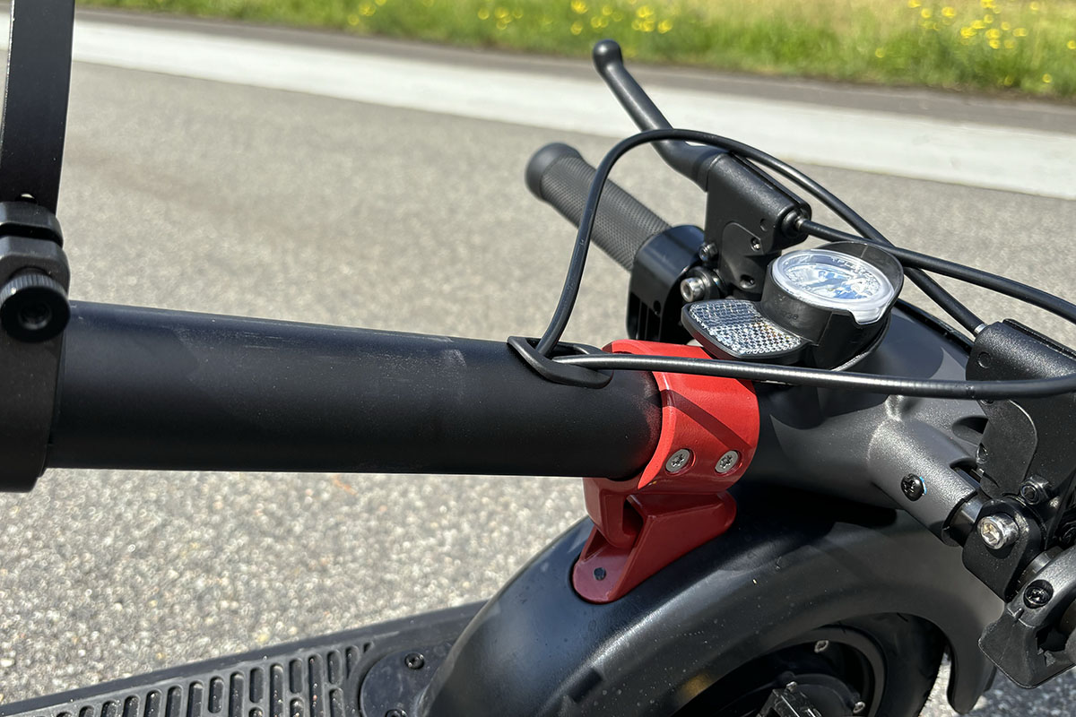 Detailaufnahme eines E-Scooter mit eingeklappten und arretierten Lenker.