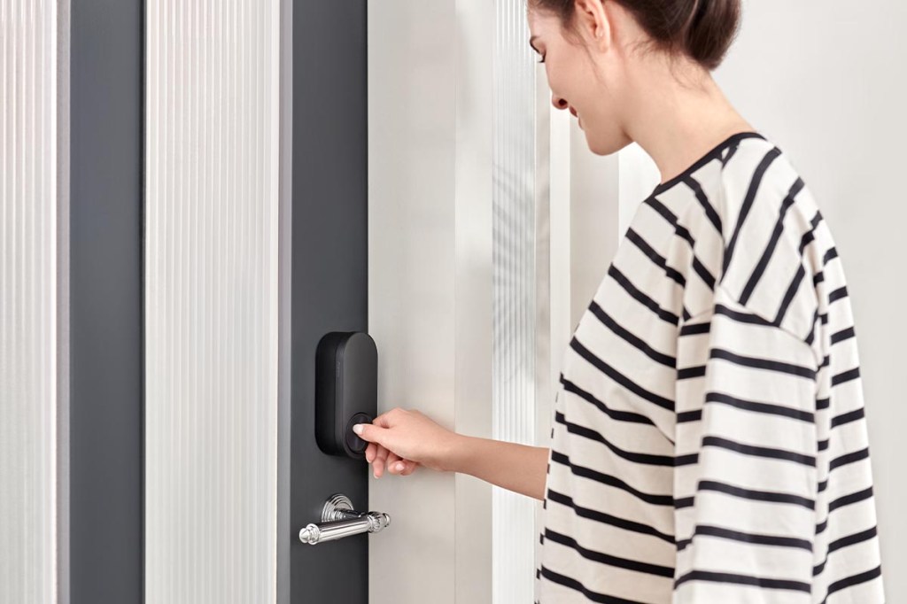 Das Smart Lock U200 von Aqara wird von einer Frau betätigt.