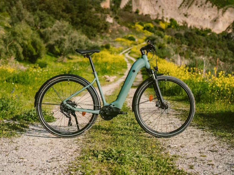 E-Bike von Decathlon auf einem Feldweg unter Sonnenschein.