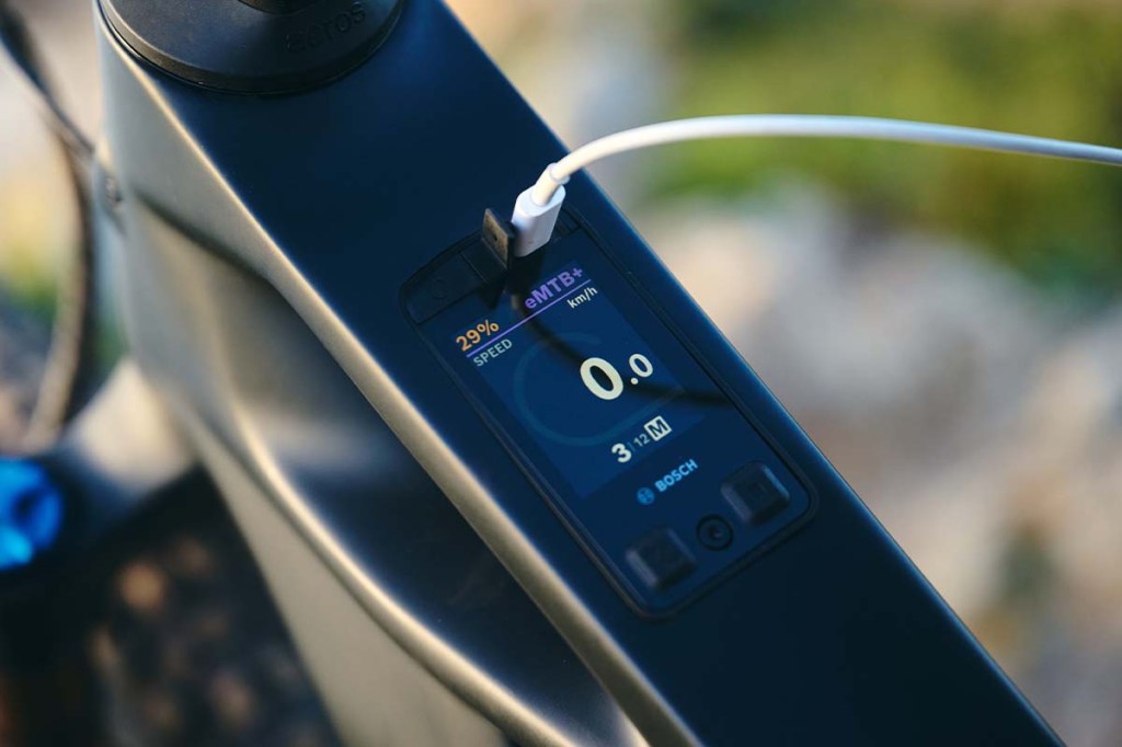 Nahaufnahme eines E-Bike Displays, das im Rahmen integriert ist, ein Kabel ist zudem an einer Buchse angeschlossen