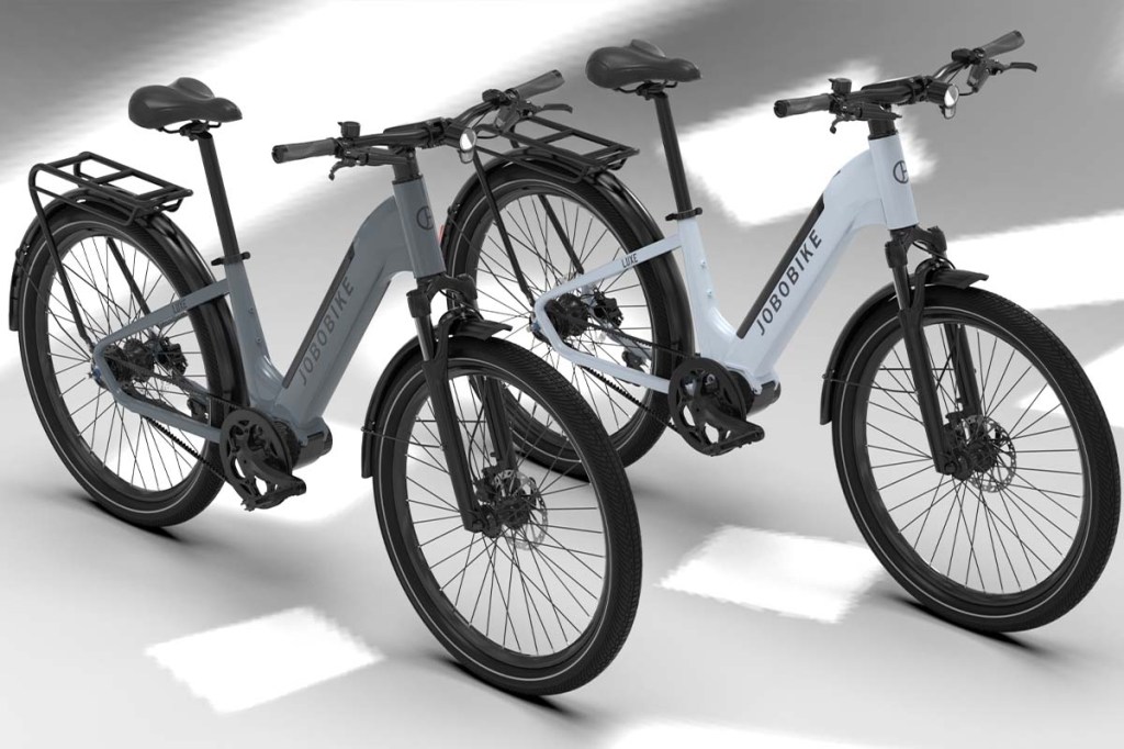 Zwei E-Bikes nebeneinadner stehend, grauer HIntergrund