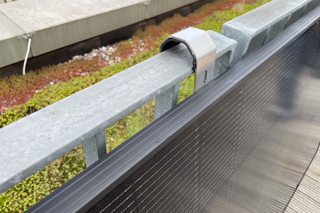 Ein Solarpanel hängt an einem Geländer.